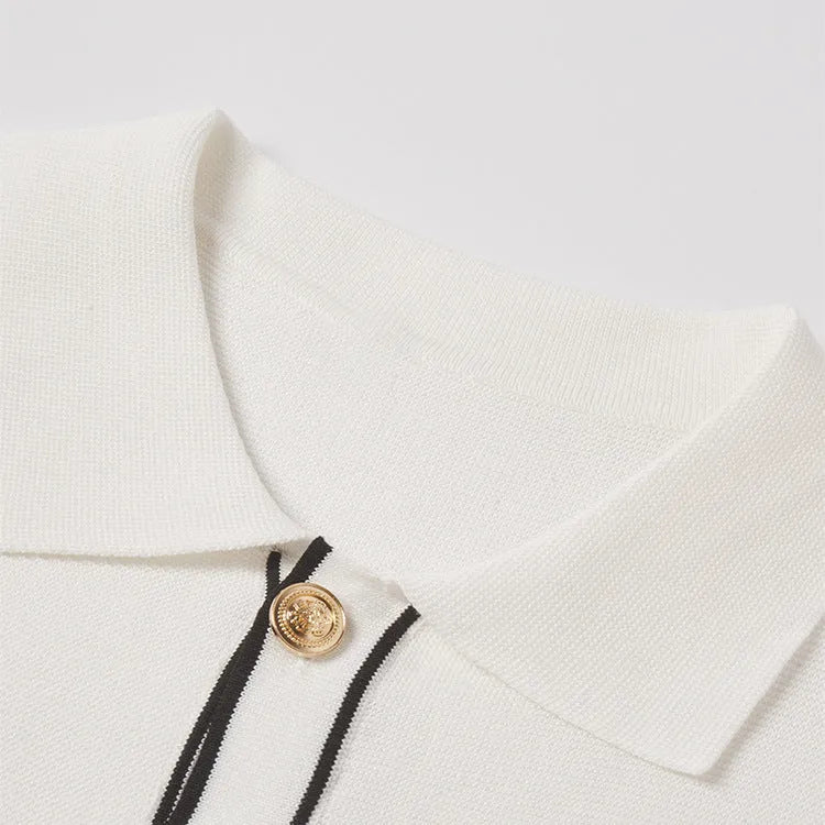 White short sleeve cardigan with dark contrast colour lapels on a hanger.