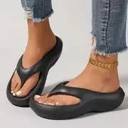 Black women's flip-flops with thick sole and textured non-slip tread.