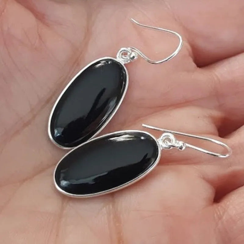 Black oval geometric earrings with Chinese style design on an electroplated alloy construction.