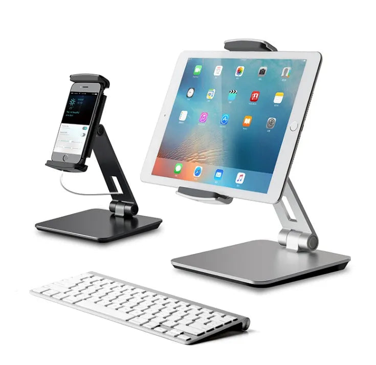 Silver foldable aluminium phone tablet stand with 360-degree rotating bracket on a desktop.