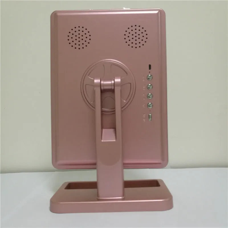 Pink and white LED makeup mirror with circular lights and Bluetooth speaker on a vanity table.