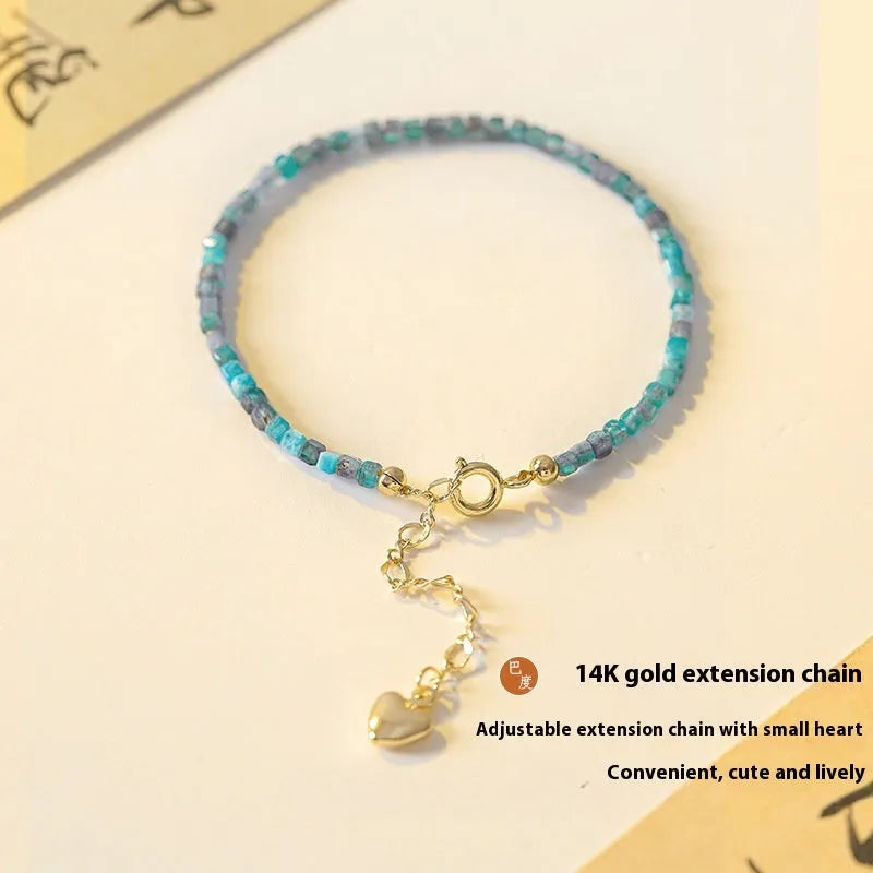 Women's blue and grey crystal bracelet with diamond faceted beads on a wrist.