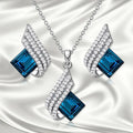 Women's electroplated necklace and earring set with alloy pendant and glass accents on cross chain