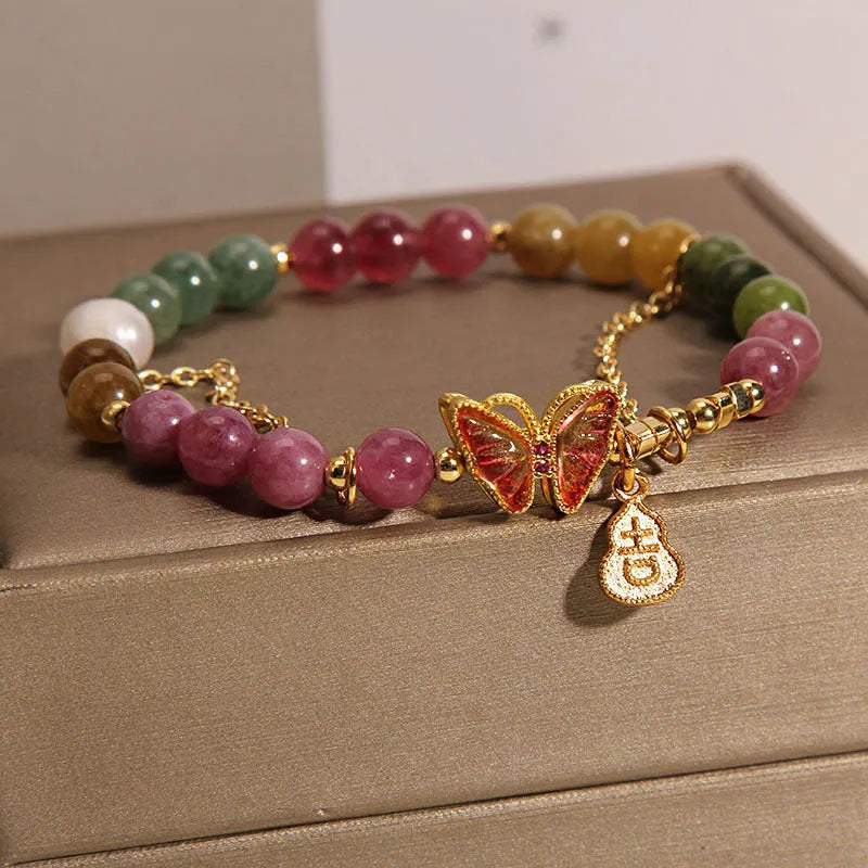 Close-up of a women's agate bracelet with a jade green tourmaline butterfly gourd bead.