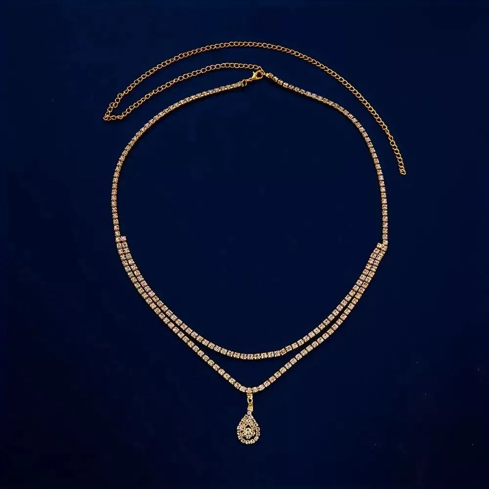 Gold rhinestone waist chain with water drop pendant and tassel on white background
