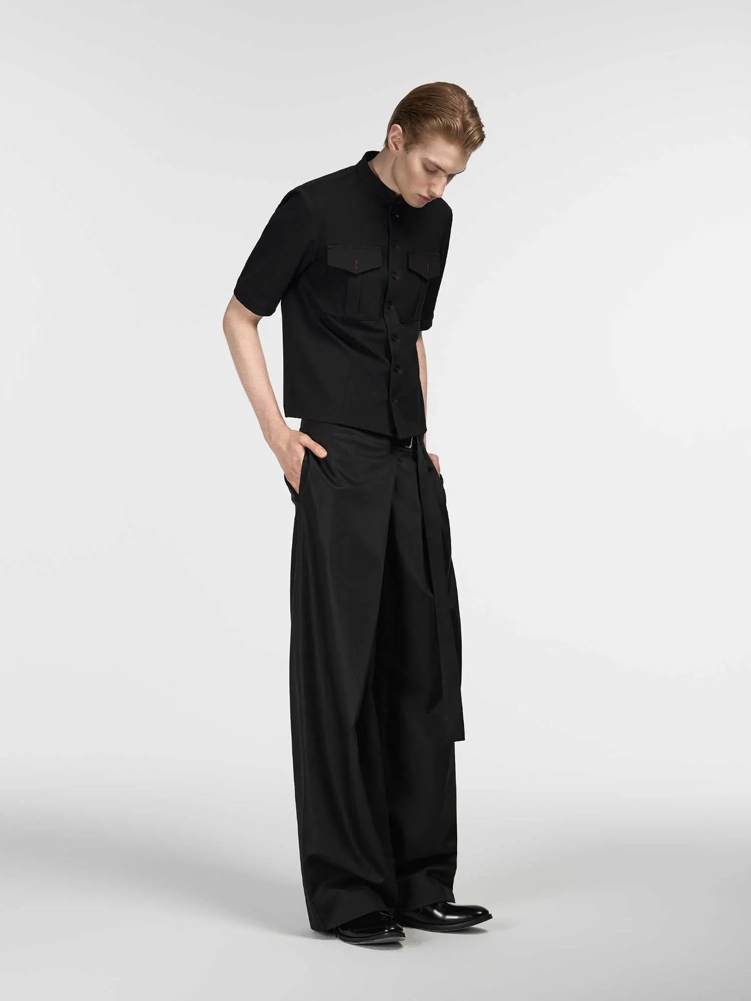 Black women's straight-leg trousers with a single pleat front and adjustable waistband on a hanger.