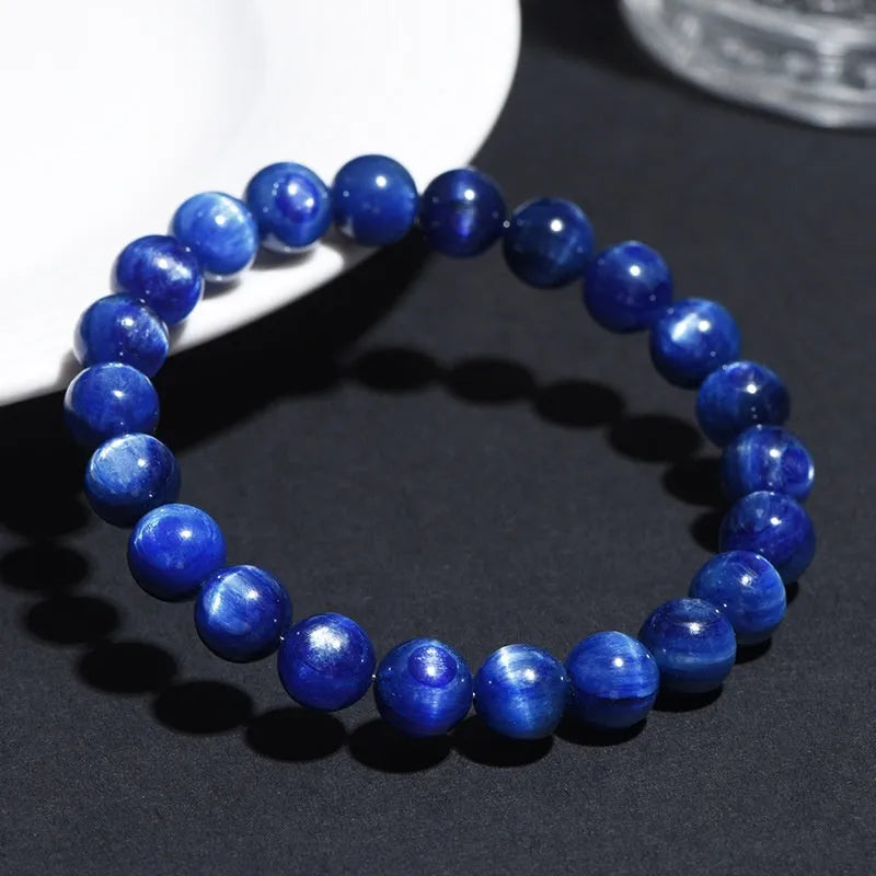Polished blue crystal bracelet with geometric beads and Ruyi charm, shown in trade fair gifting context