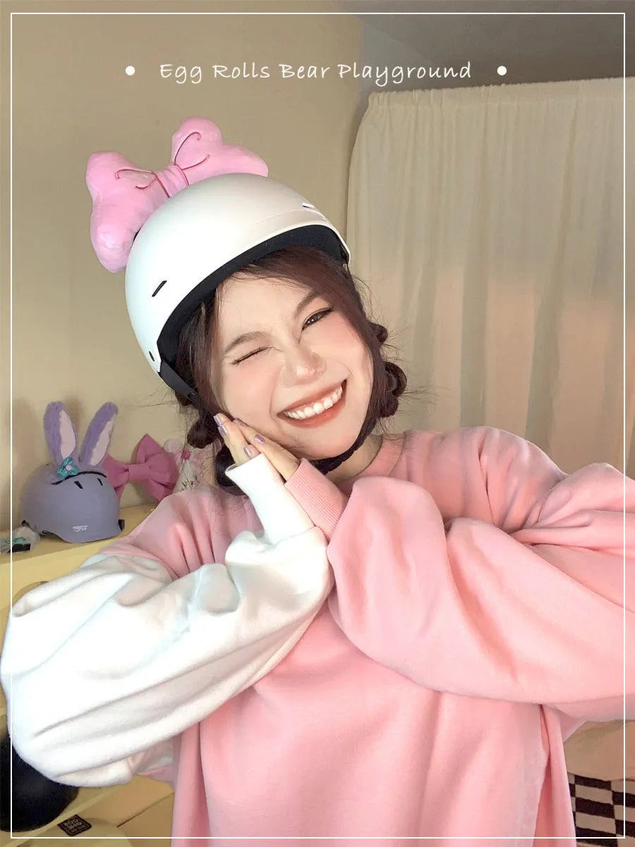A soft plush bow decoration for helmets in red, peach pink, and rose pink colours.