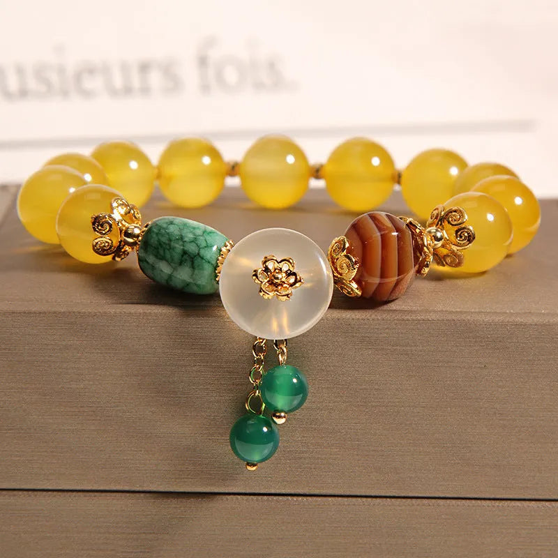 Yellow agate crystal bracelet with gold silk cord on wrist showing adjustable closure and bead detail