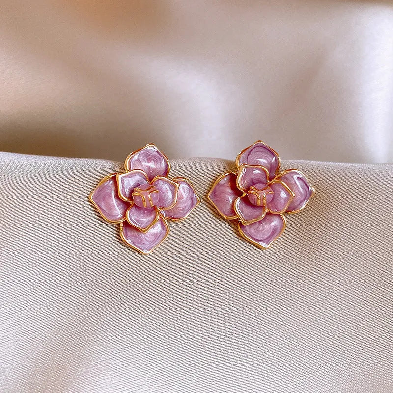 Close-up of a purple oil-spot glaze flower stud earring with a gold-plated needle on a copper base.