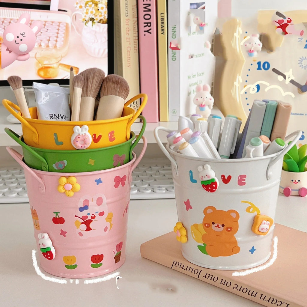 Round metal creative iron art pen holder on a desk, shown in a choice of solid colours or with sticker patch accents.