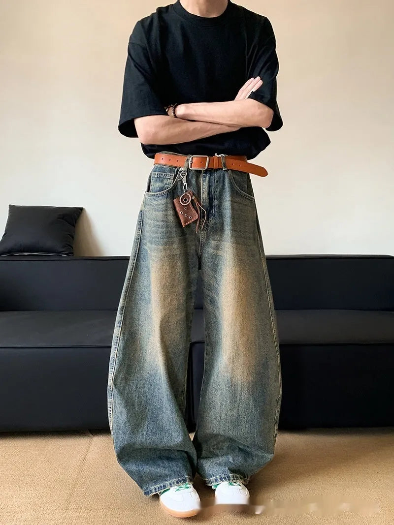 Men's retro blue distressed denim jeans with slim fit wide leg design showing machete wash detailing