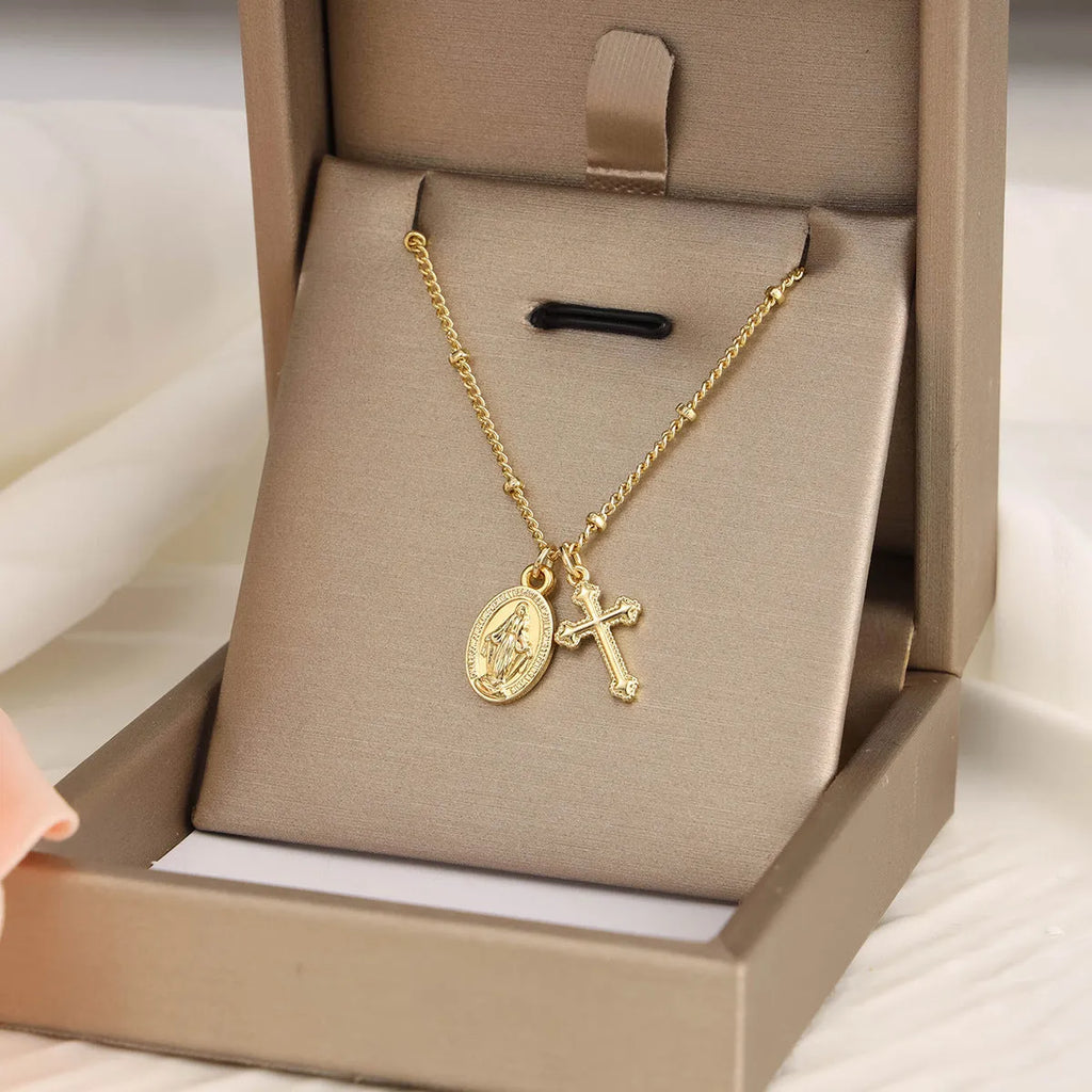 Gold coloured geometric cross necklace with a Virgin Mary ornament pendant for women.