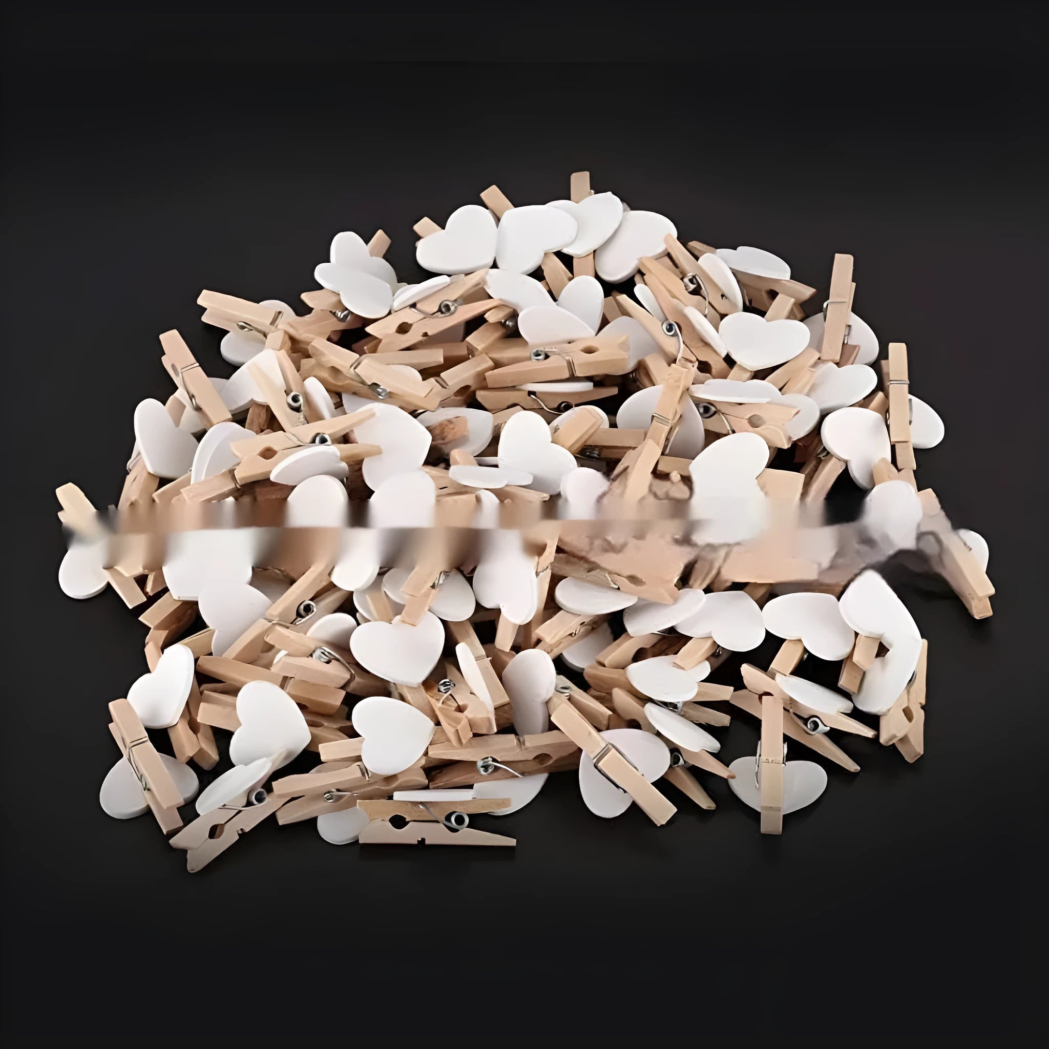 Five handmade wooden heart-shaped clips in red, white, and rose red on a surface.