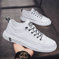 Men's casual white PU leather shoes with round toe and low flat heel on a beige background.