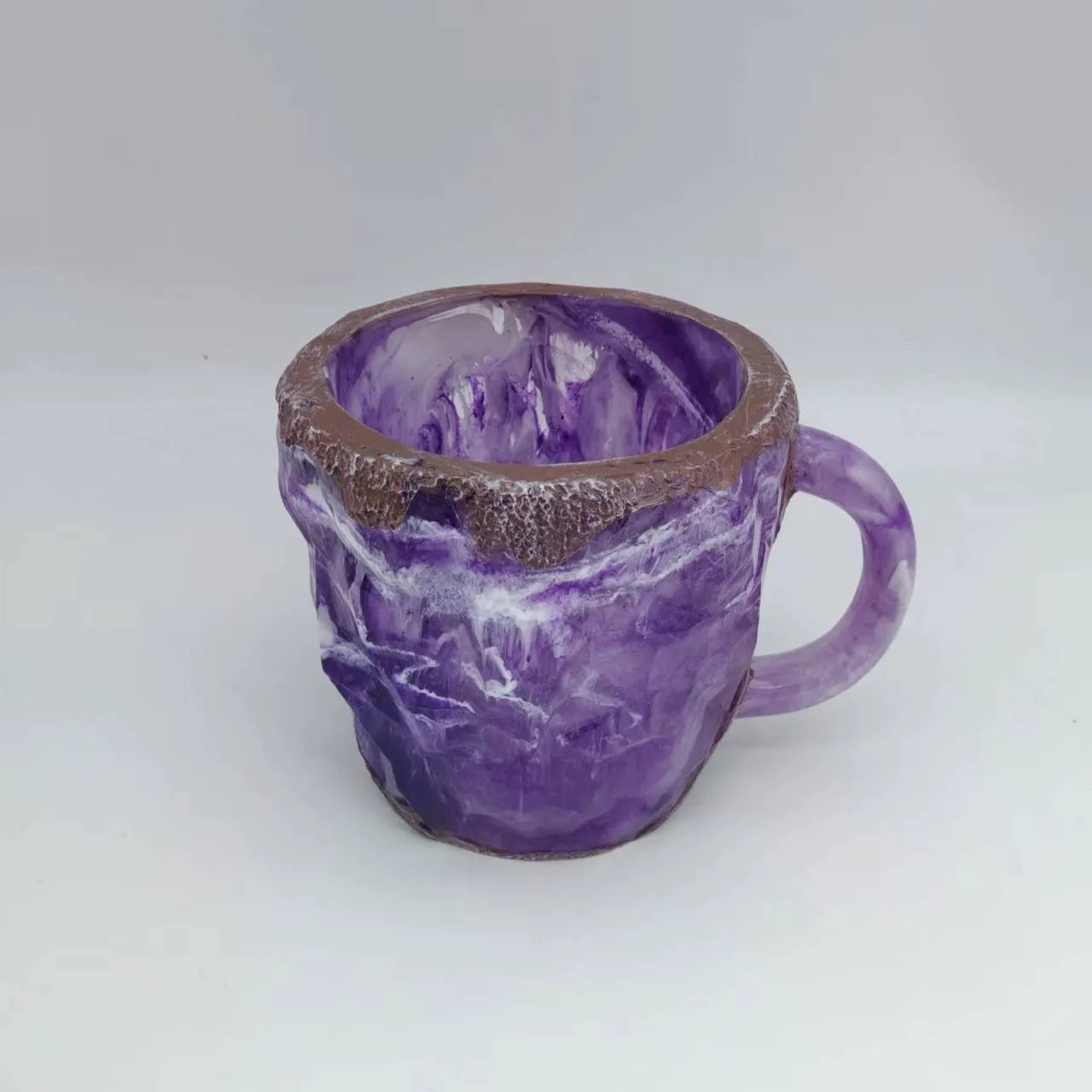 Purple resin coffee mug with handle showing crystal-like transparency on a table.