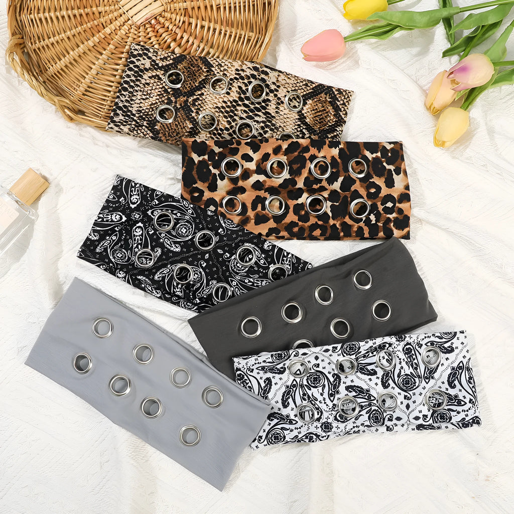 A black polyester exercise hair band with a hollow metal decorative centrepiece.