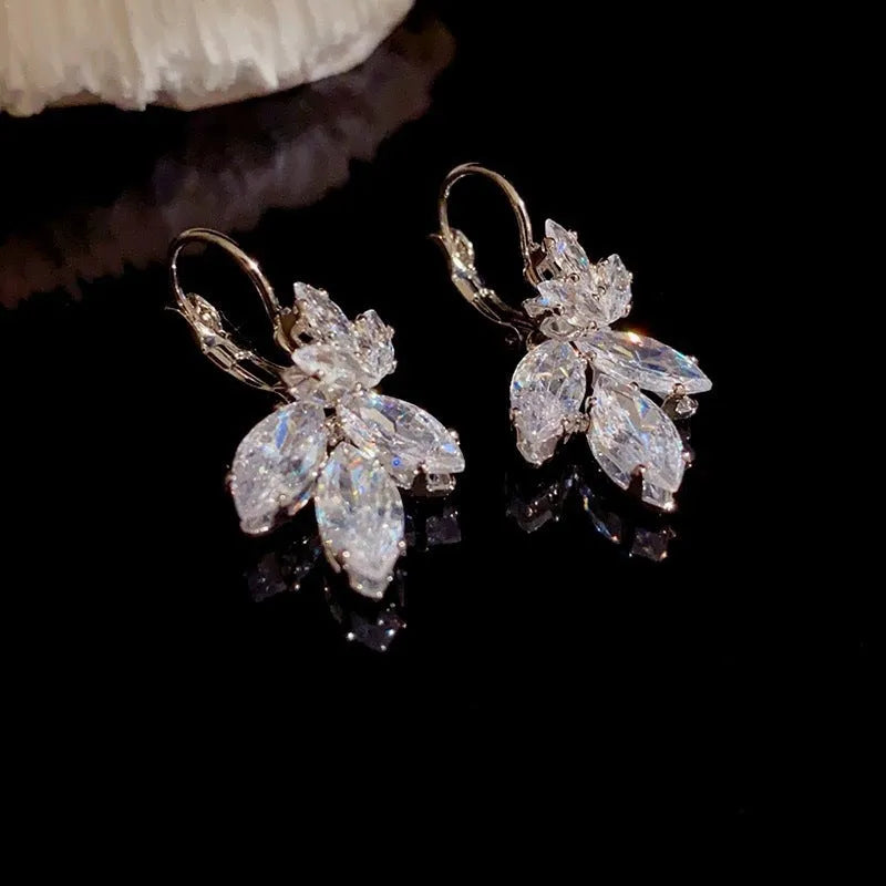 Women's platinum colour leaf earrings with inlaid zircon detailing on alloy background