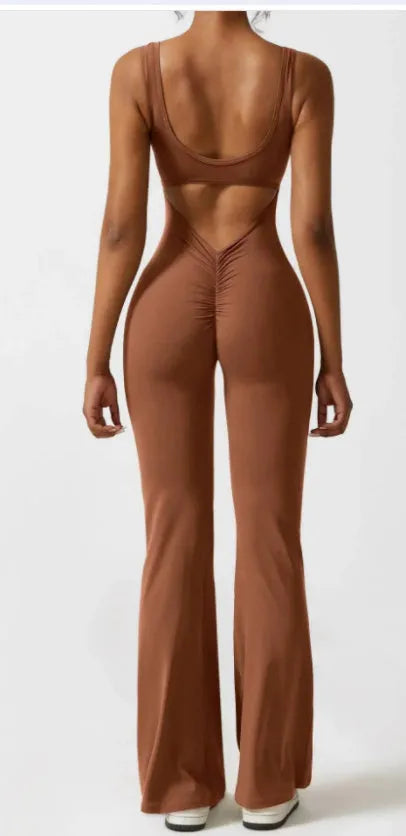 Black seamless women's yoga bodysuit jumpsuit with built-in chest pad, shown on model.