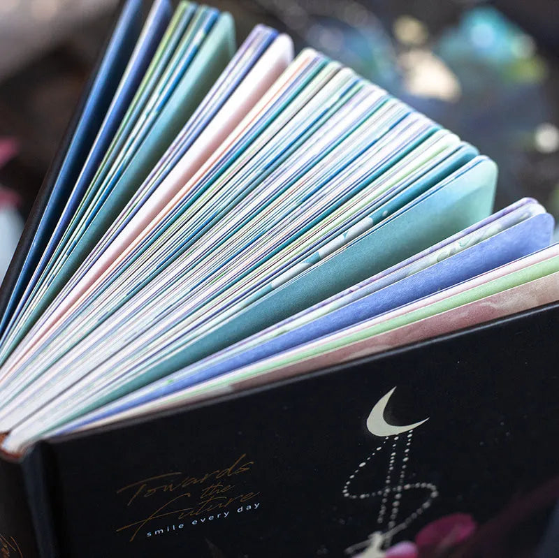 A5 notebook with a luminous blue cover, open to show white paper and a colour illustration page.