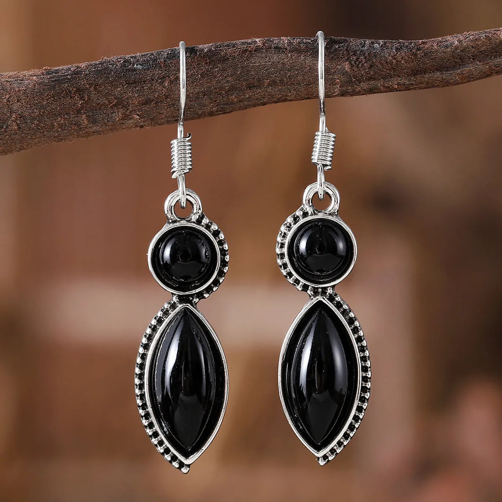 A pair of vintage-style geometric drop earrings in black and purple with a round element, bohemian jewellery.