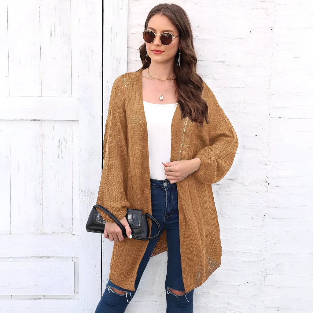 A women's loose-fitting solid colour acrylic sweater coat on a hanger.