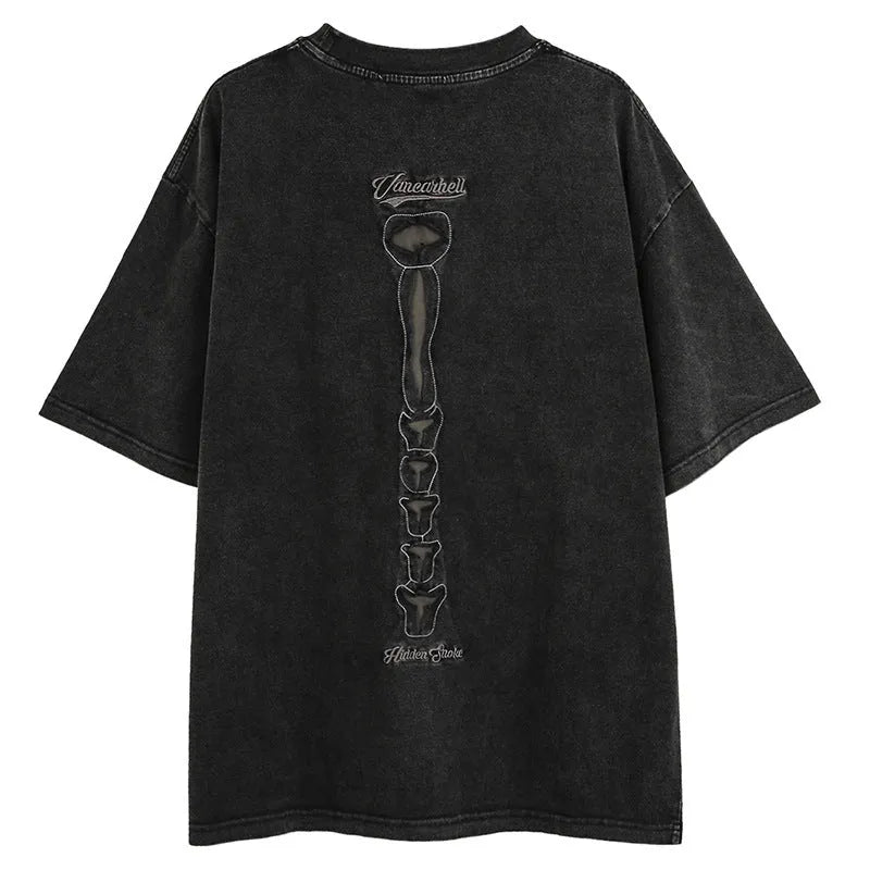 Man wearing a black loose-fit cotton t-shirt with a large skull and letter graphic on the front.