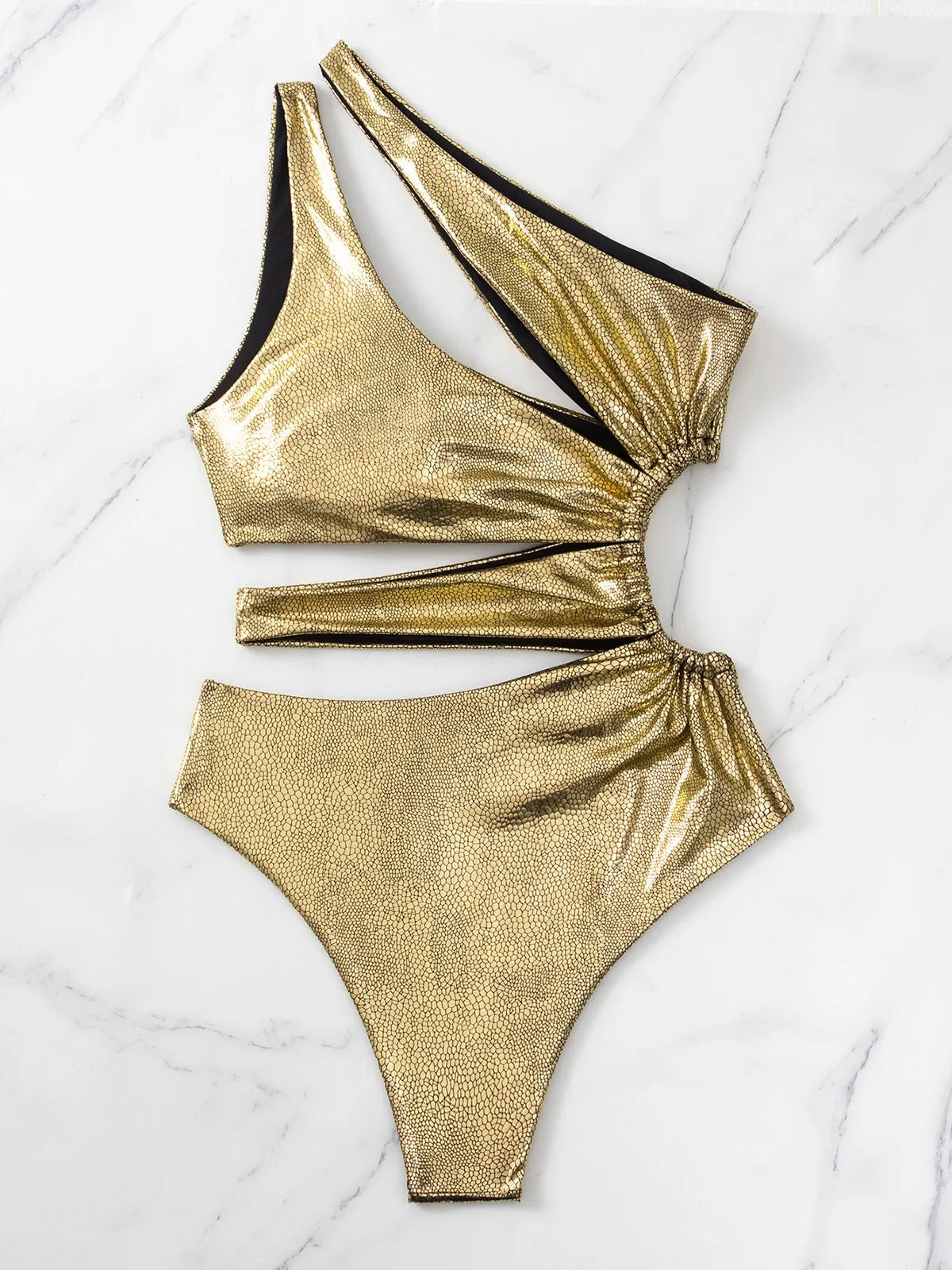 Women's gold backless one-piece swimsuit on a mannequin, showing sleeveless design.