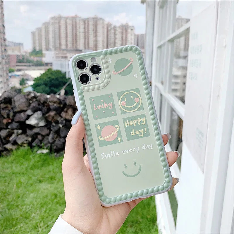 Green iPhone case with geometric smiley face and polka dot patterns, slim TPU back cover design
