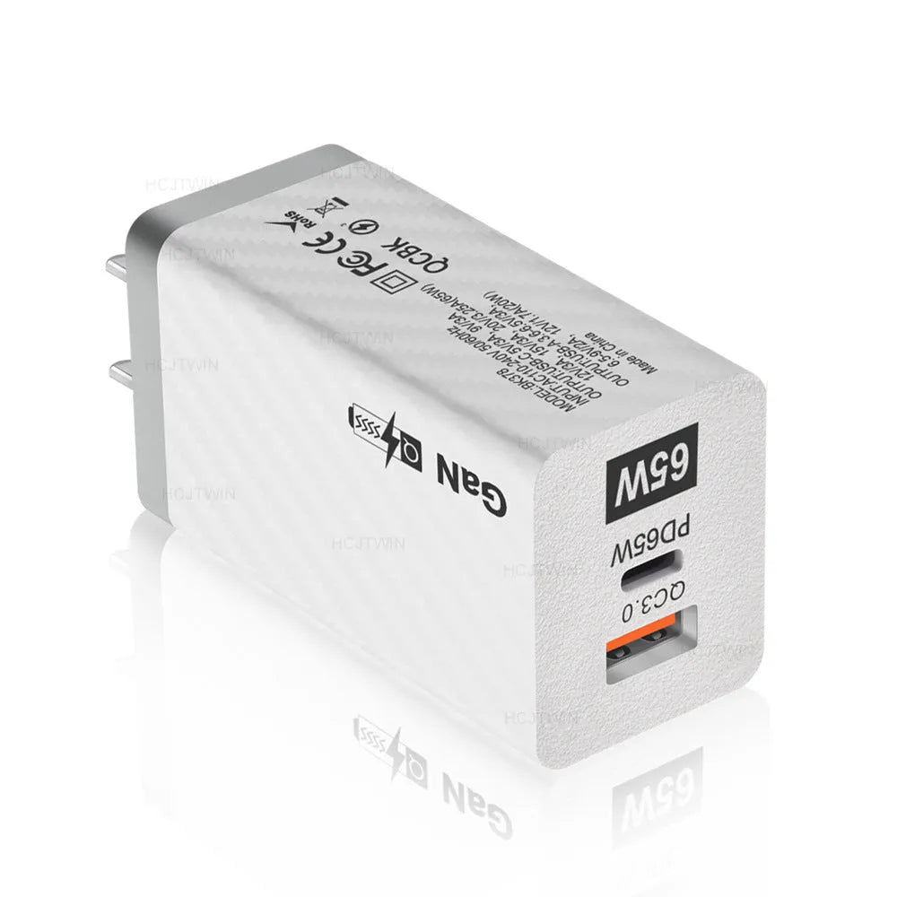 White GaN universal laptop charger with USB-C port showing compact dimensions next to UK plug