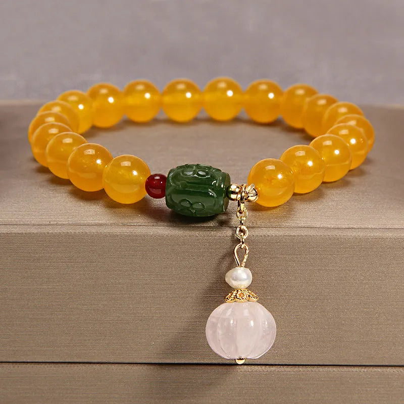 Yellow agate crystal bracelet with gold silk cord on wrist showing adjustable closure and bead detail