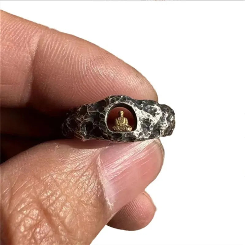 Close-up of a hand-forged copper Buddha ring with a grotto rock texture.