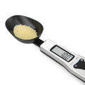 Digital smart measuring spoon with LCD screen showing weight, placed next to mixing bowl.
