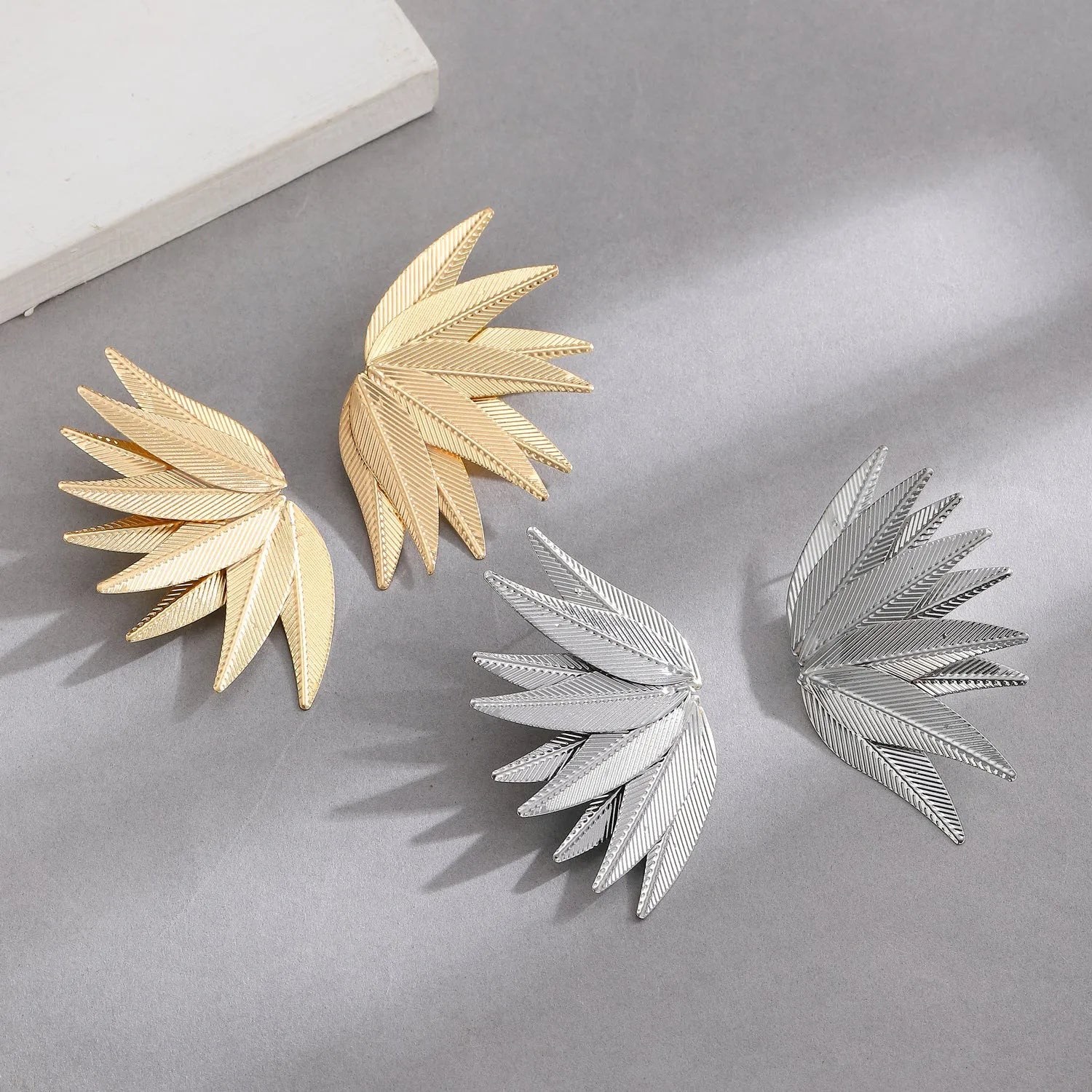 Gold and white leaf-shaped alloy patch earrings showing botanical design