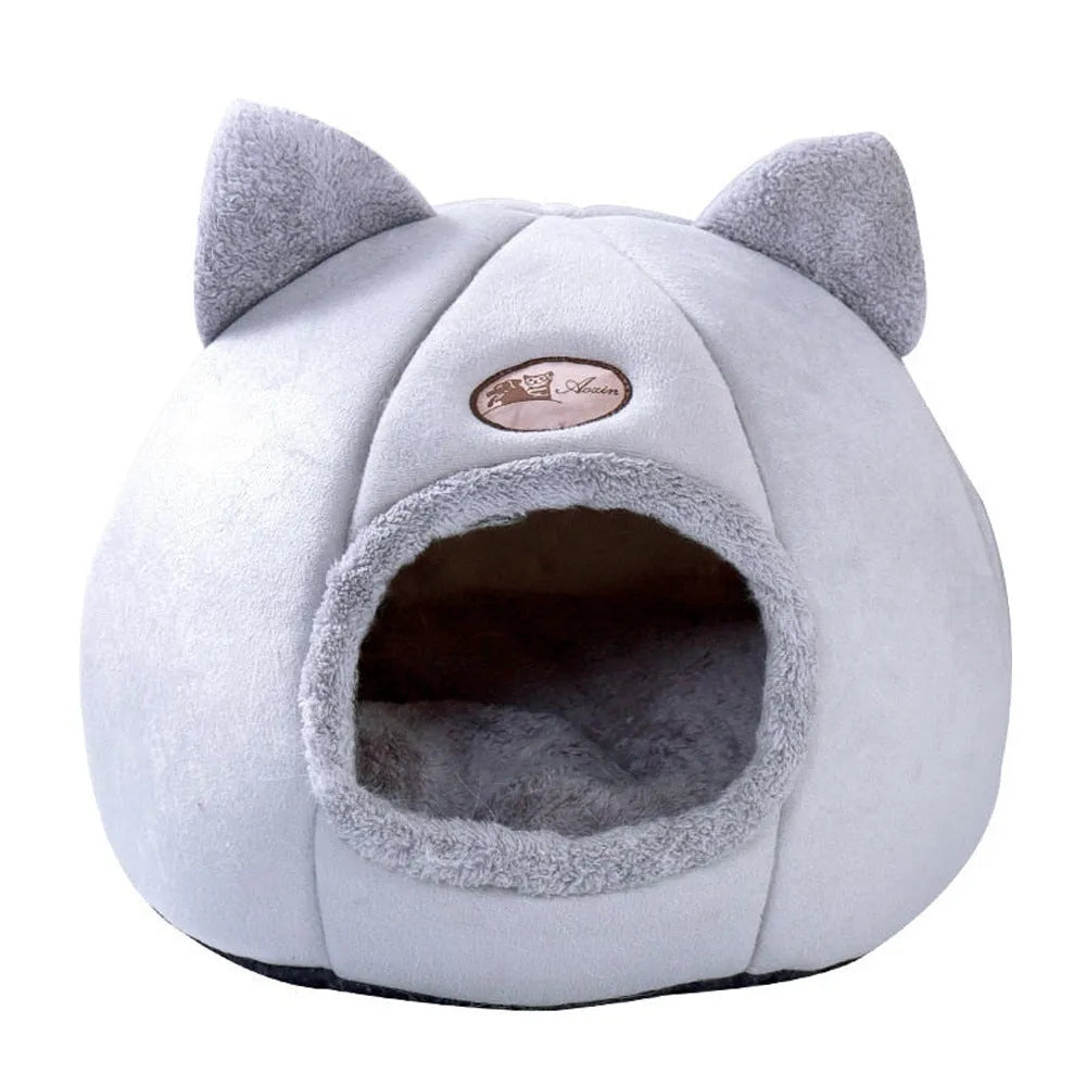A fully enclosed cube-shaped cat sofa nest, showing the entrance hole, in a home setting.