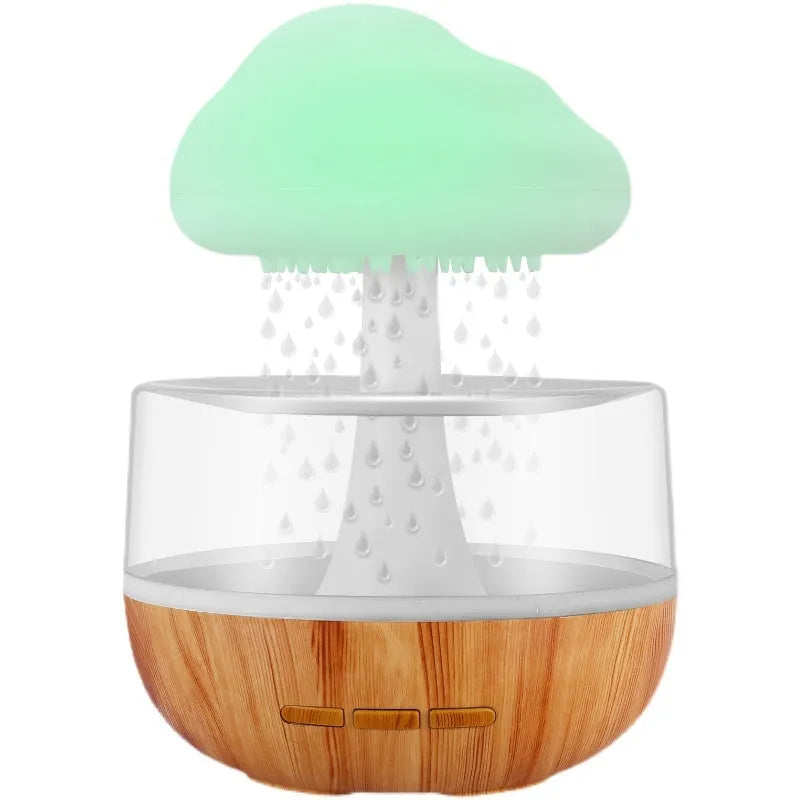 White cloud-shaped humidifier with multi-colour night light and essential oil diffuser on a table.