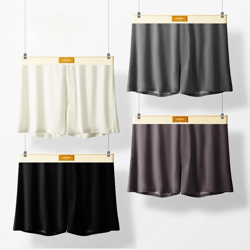 Three pairs of solid colour men's loose fit ice silk boxers laid flat, showing beige apricot, black, and dark grey.