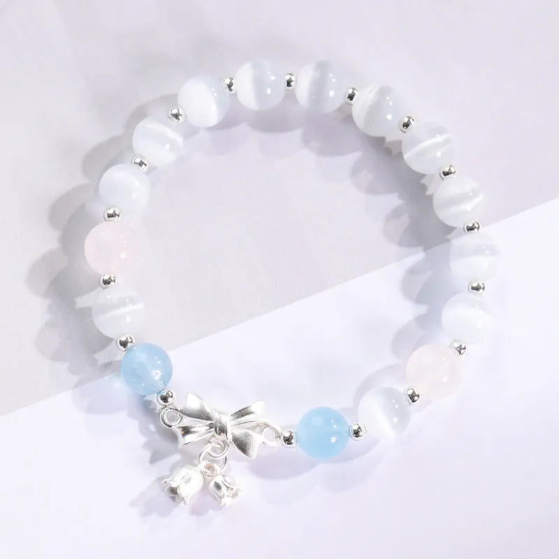 Women's opal cat's eye stone bracelet with diamond-shaped beads on wrist.
