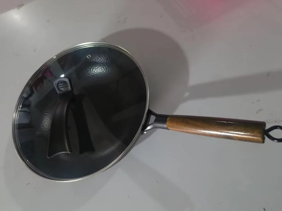 Black traditional iron wok with wooden handle measuring 32cm diameter with induction base