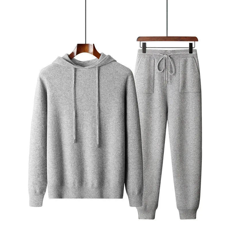 Man wearing a light grey hooded cashmere sweatshirt and matching casual trousers.