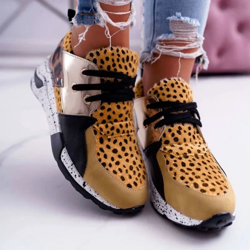 Women's black suede casual sneakers with a wedge heel and round toe on a plain background.