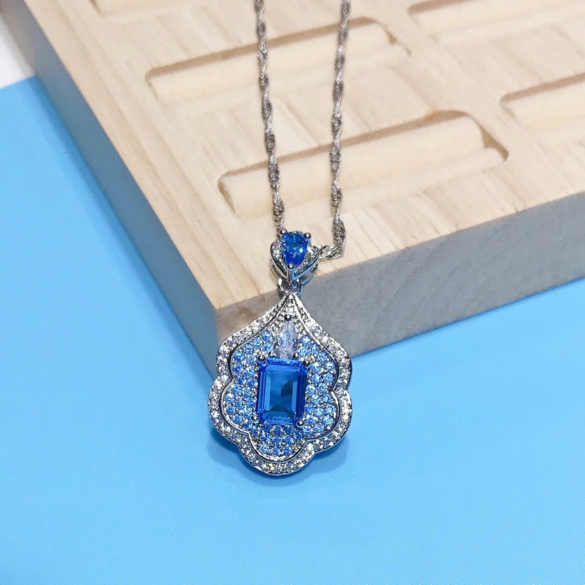 Sea blue geometric copper pendant charm with aquamarine topaz design, shown without a chain.
