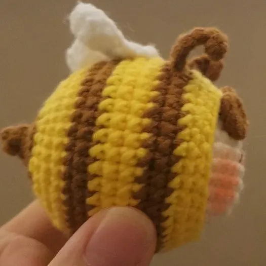 Handmade crocheted bee colony pendant accessory for a woolen doll.