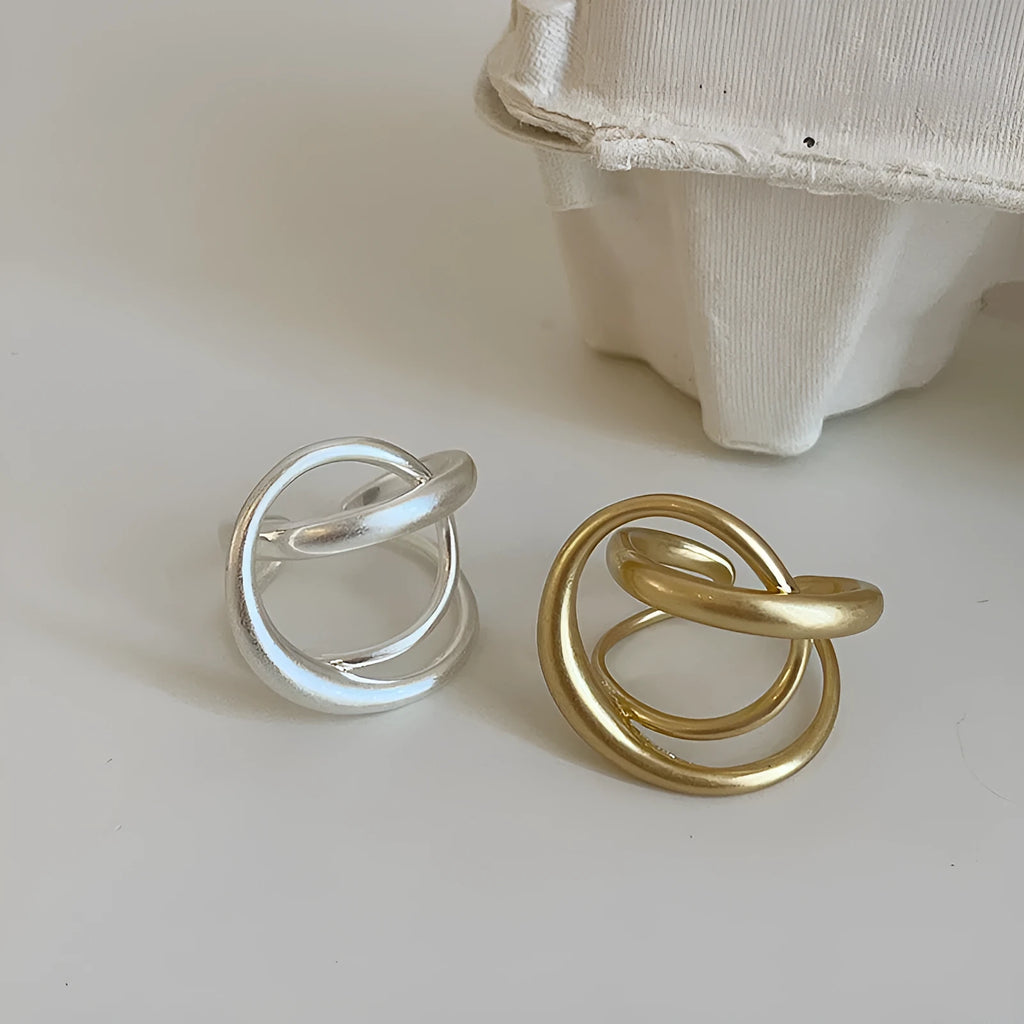Women's geometric open ring with three-dimensional interlaced matte metal design in gold or silver with real gold electroplating