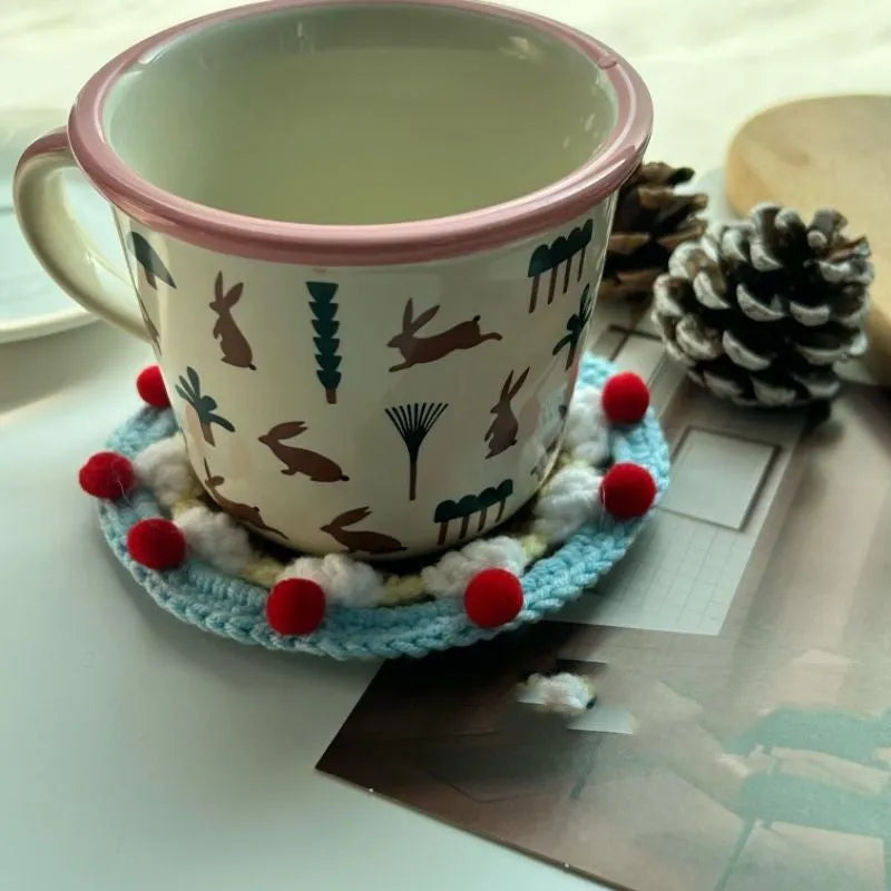 Handmade round wool coaster bag for hot mugs on a table