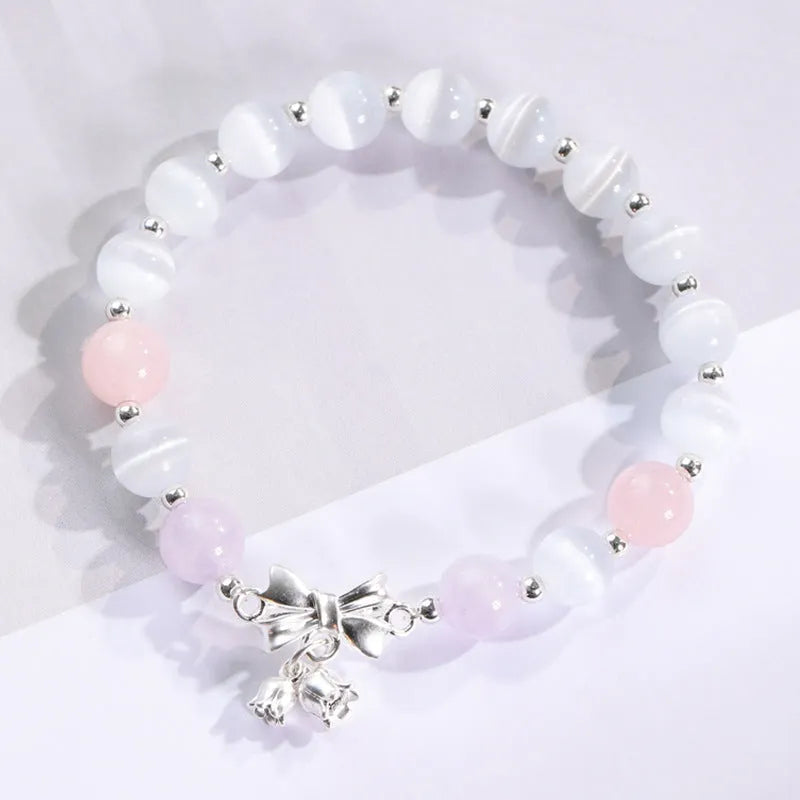 Women's opal cat's eye stone bracelet with diamond-shaped beads on wrist.