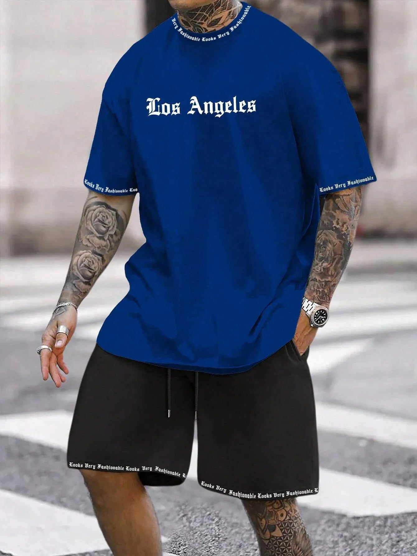 Man wearing a blue printed sports-style short-sleeve top and matching shorts set.
