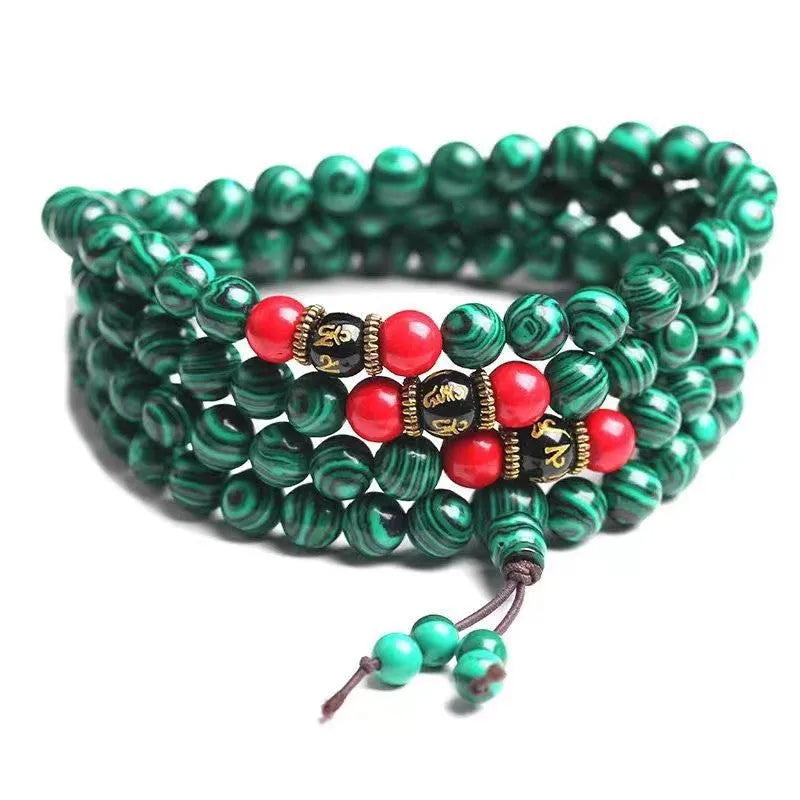 Multi-layer turquoise Tibetan bracelet with 108 round polished beads, shown in hand.