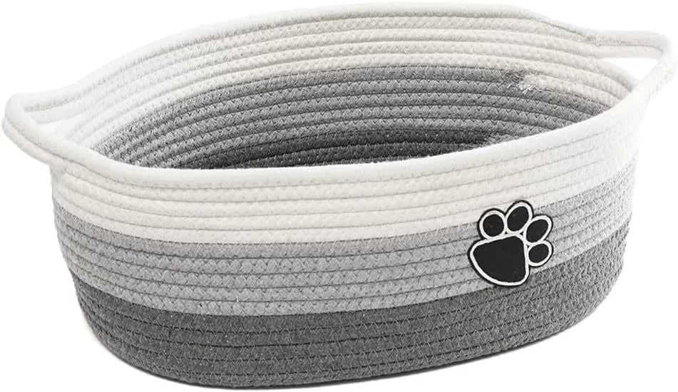 Small light beige woven cotton rope storage basket with a handle on a wooden surface
