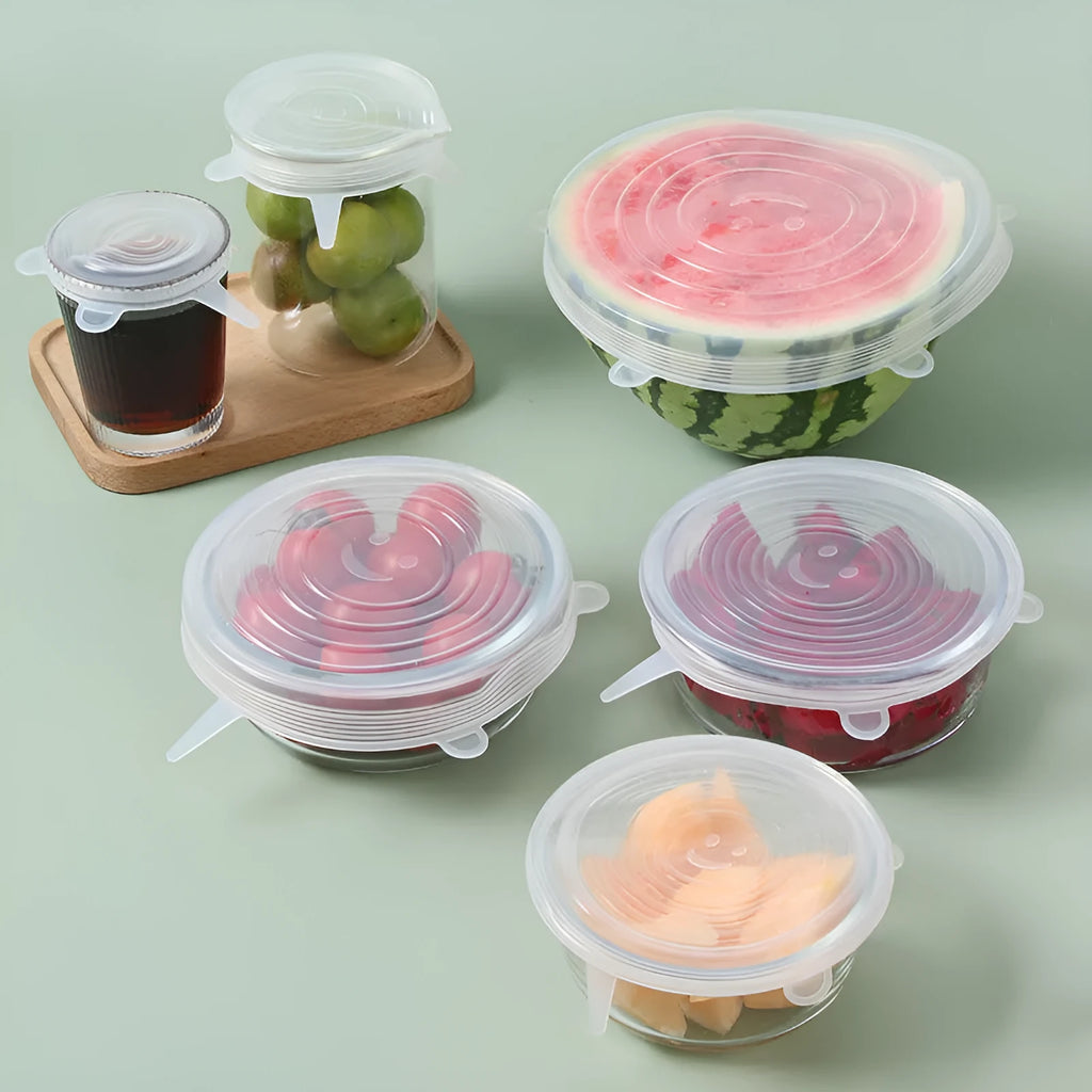 Set of six colourful silicone stretch lids in different sizes arranged on a kitchen counter.